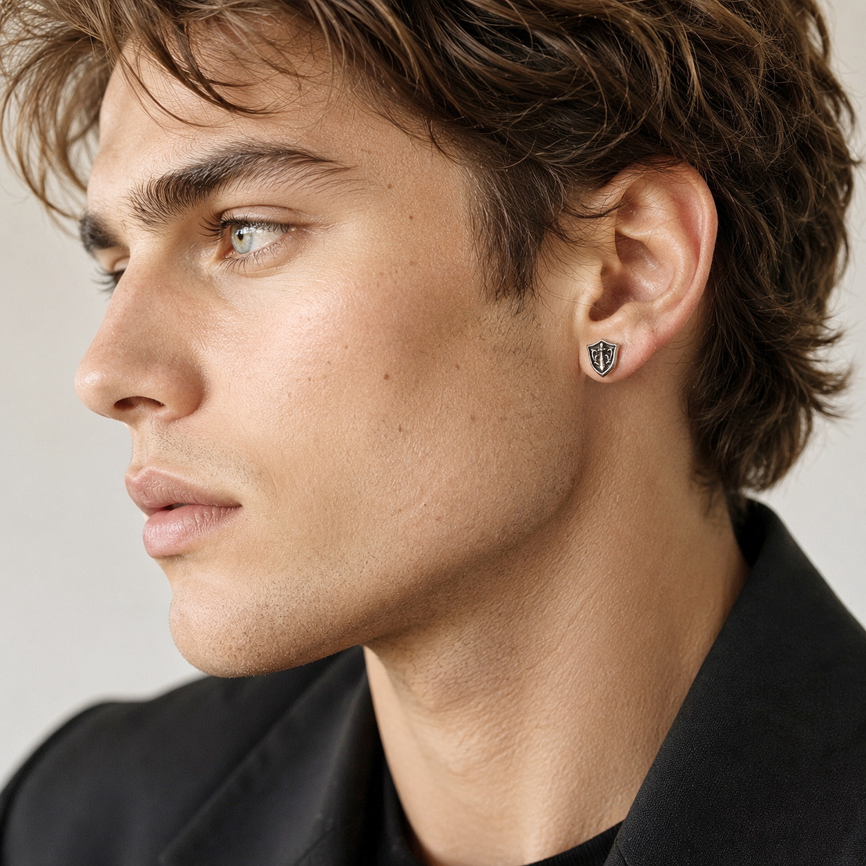 Portrait of a model wearing the sterling silver sword and shield stud earrings.