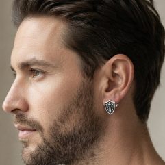 Profile shot of a model wearing the sterling silver sword and shield stud earrings.
