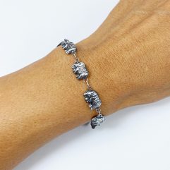 Double-sided sterling silver elephant bracelet showing adjustable clasp on wrist.