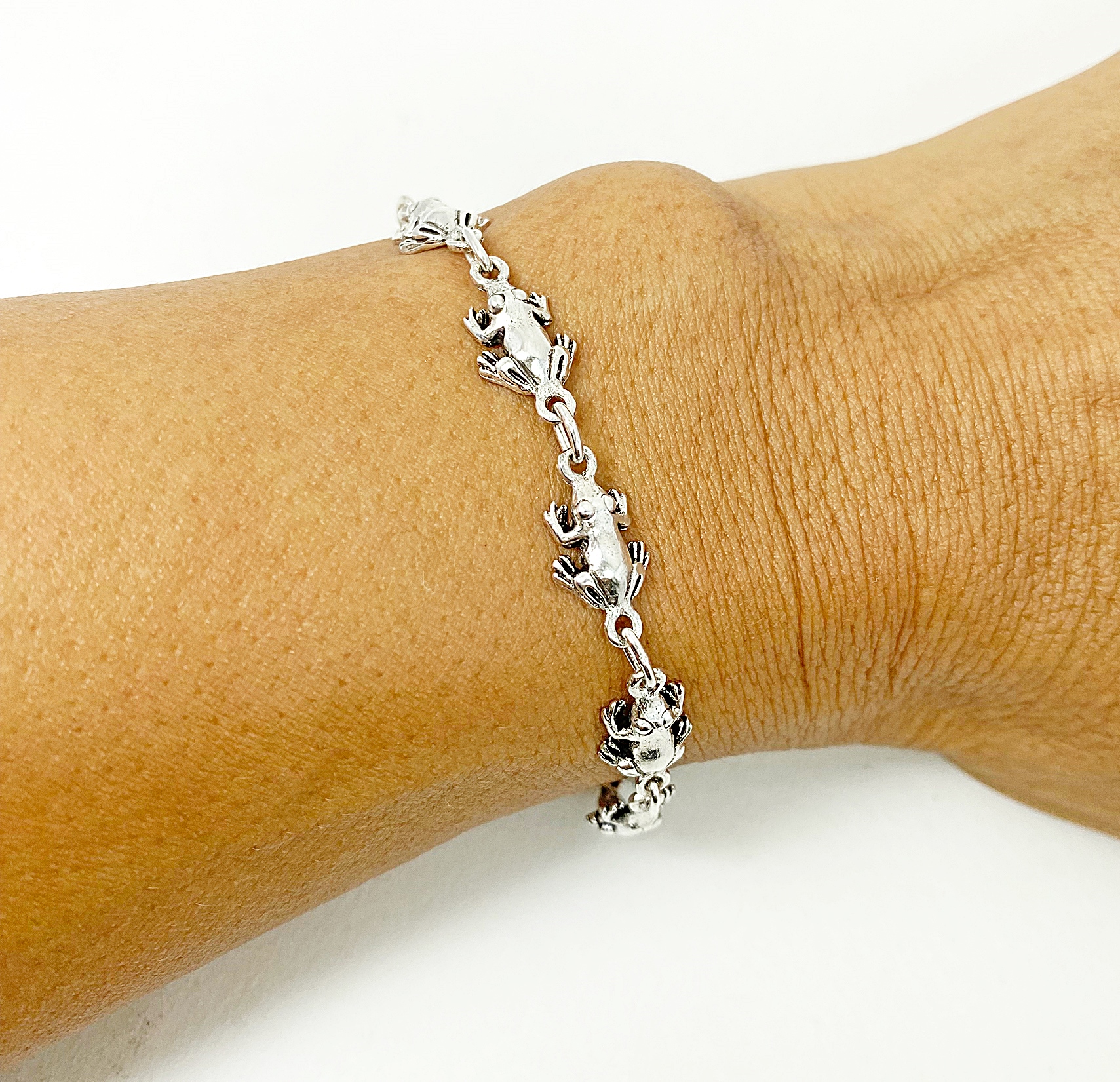 925 sterling silver frog link chain bracelet on wrist showing handmade frog details.