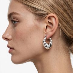 Model wearing high-polished 925 sterling silver ribbed puffy heart hoop earrings.