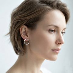 A side profile of a woman with short hair wearing delicate 10mm sterling silver circle threader earrings.