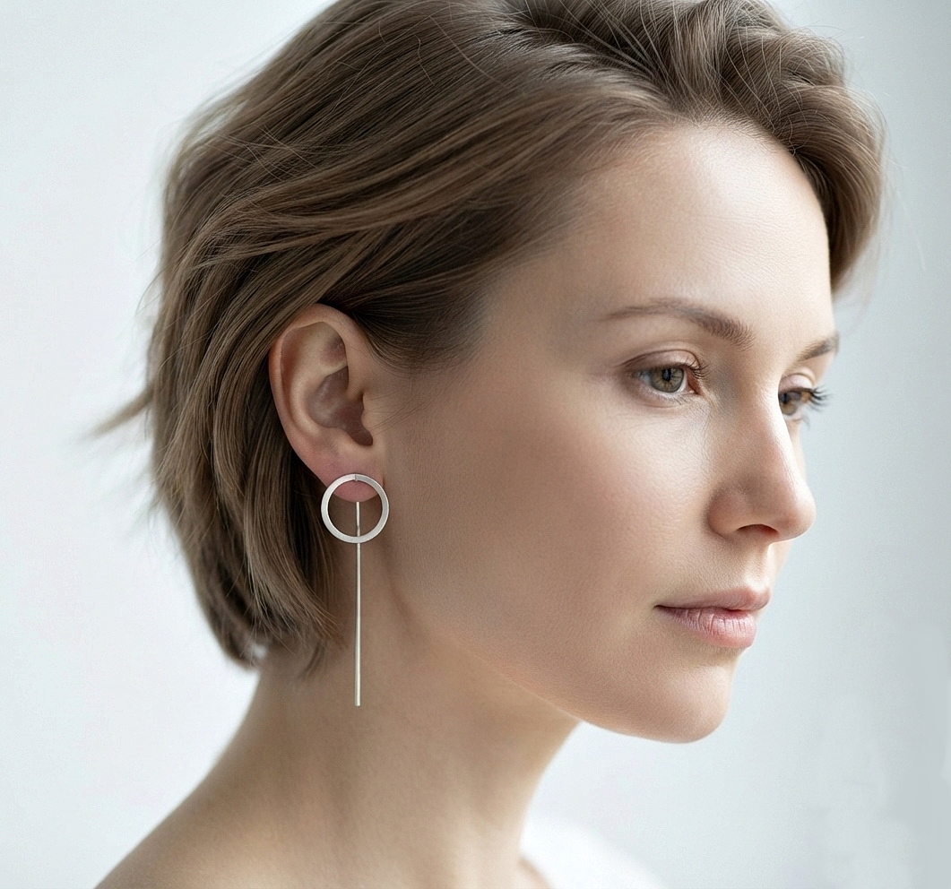 A side profile of a woman with short hair wearing delicate 10mm sterling silver circle threader earrings.