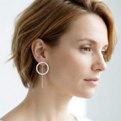 A side profile of a woman with short hair wearing delicate 20mm sterling silver circle threader earrings.