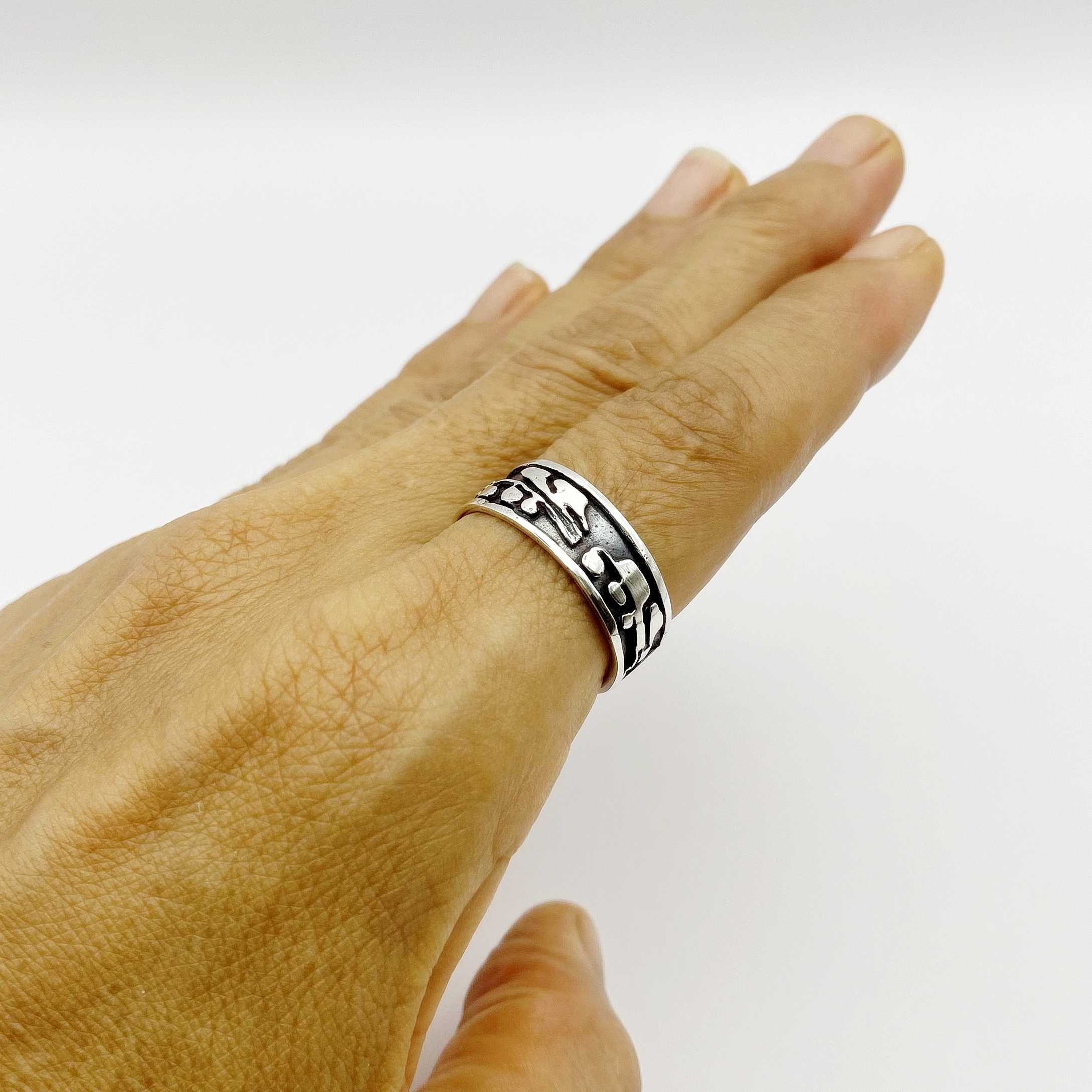 Side profile of a hand showcasing the fit of a silver leaf band on the index finger.