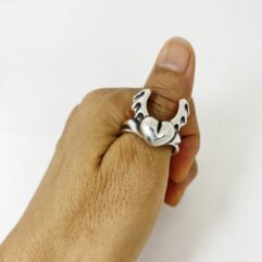 Close-up of a model wearing the silver winged heart ring, demonstrating how it fits on the finger.