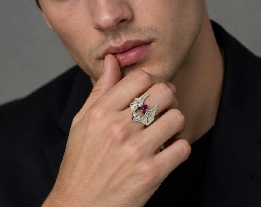 A lifestyle model wearing a black shirt, posing to showcase the sterling silver bat ring on his finger