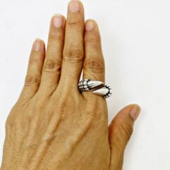 Main view of a handmade solid 925 sterling silver dual talon bypass ring worn on a model's hand.