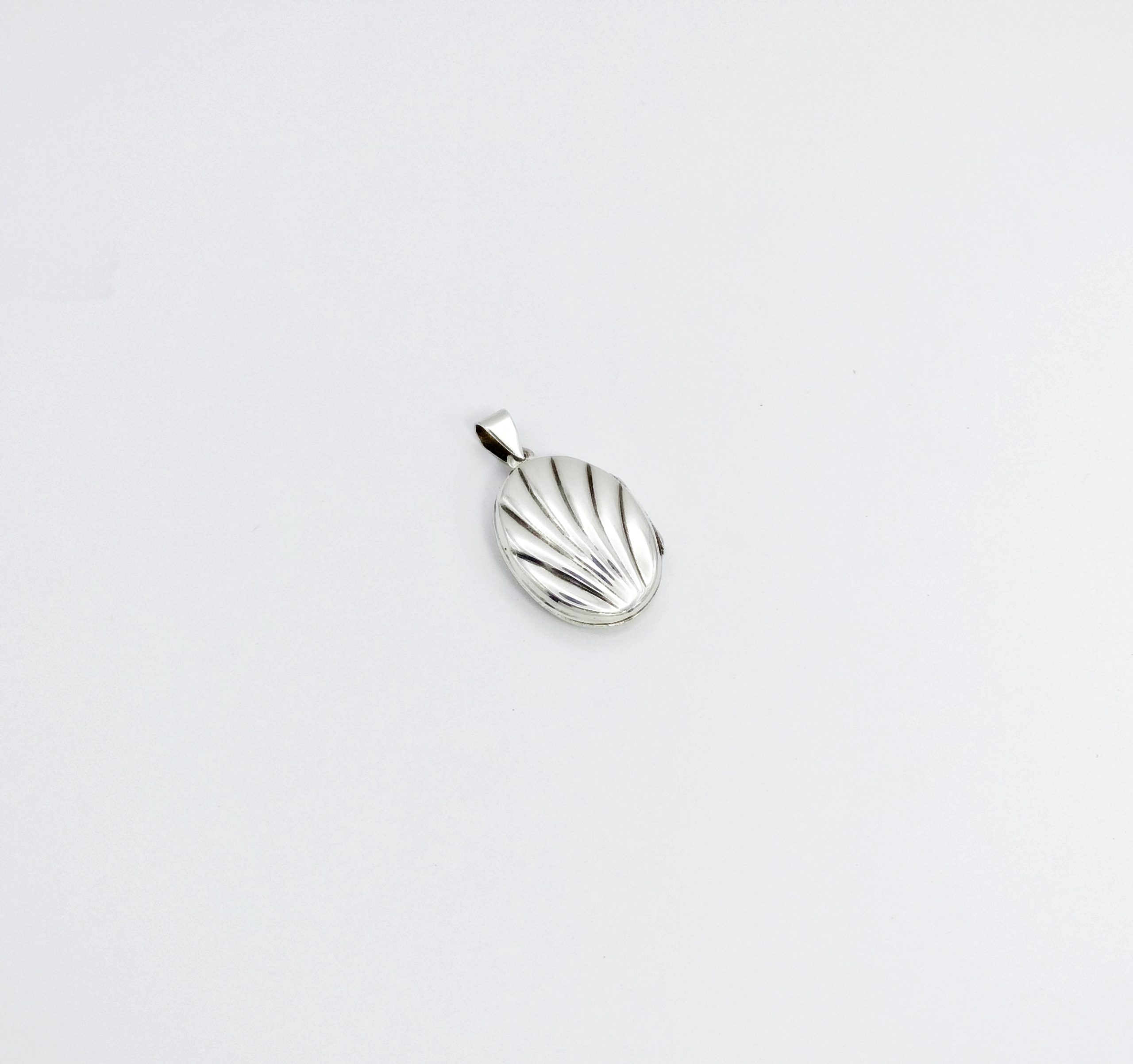 Right side profile view of a 925 sterling silver oval locket pendant, highlighting the textured front shell cover and the secure hinge.