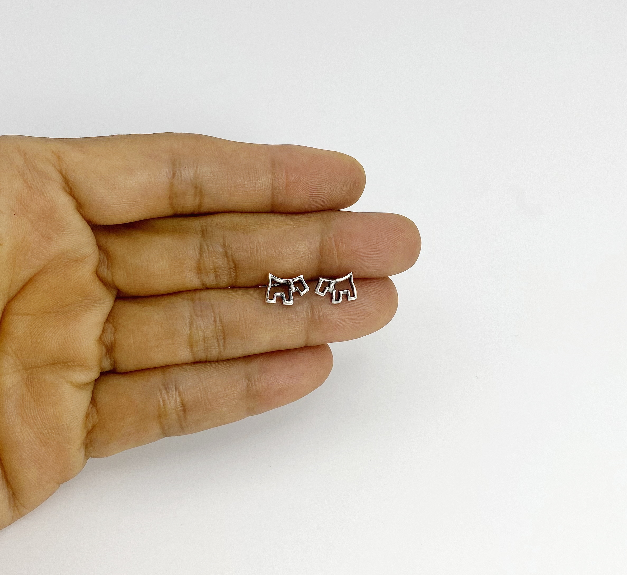 925 sterling silver minimalist outline dog earrings held in hand