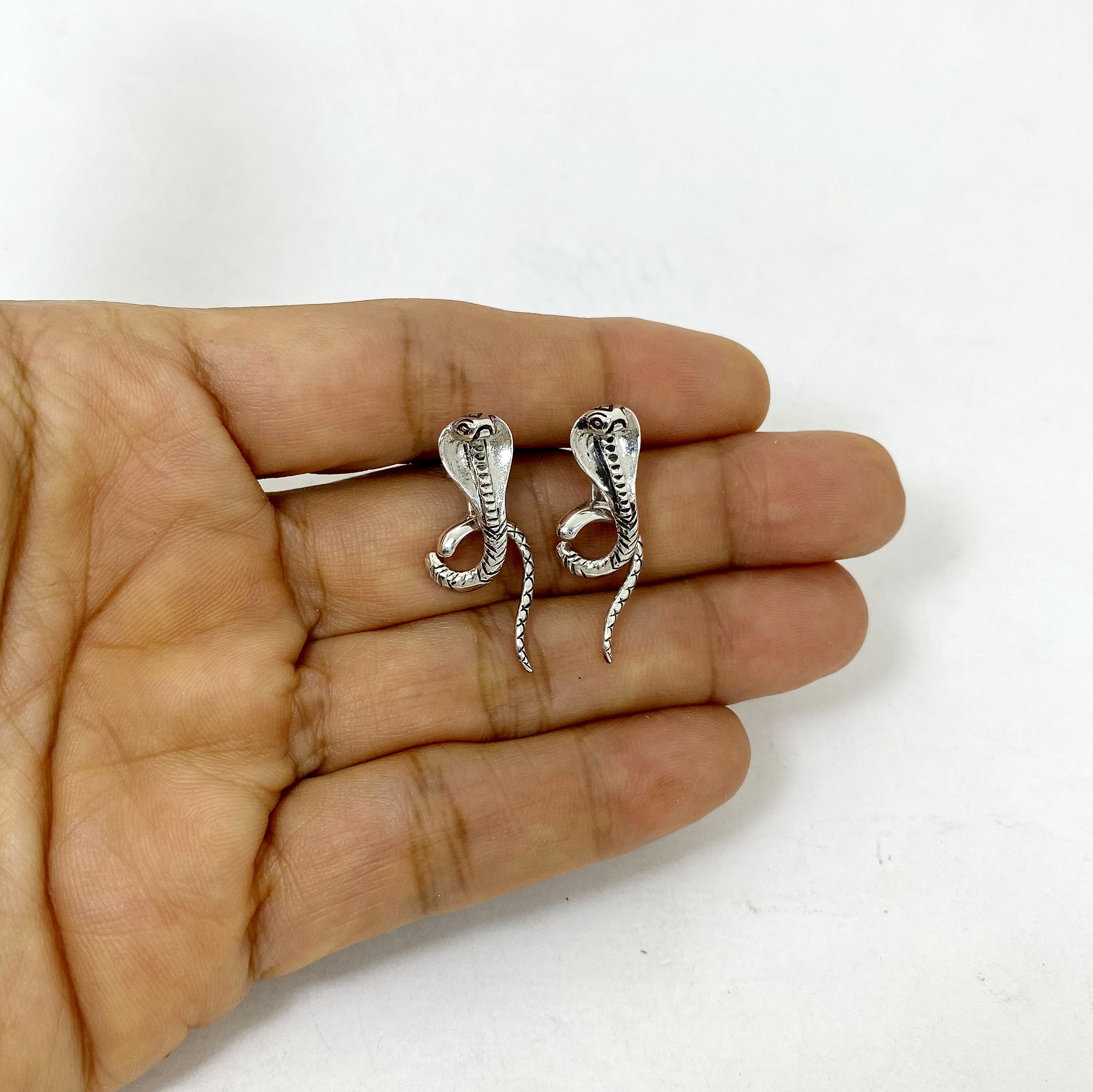 King Cobra Earring Jackets crafted from 925 sterling silver resting gently on an open palm to show scale.