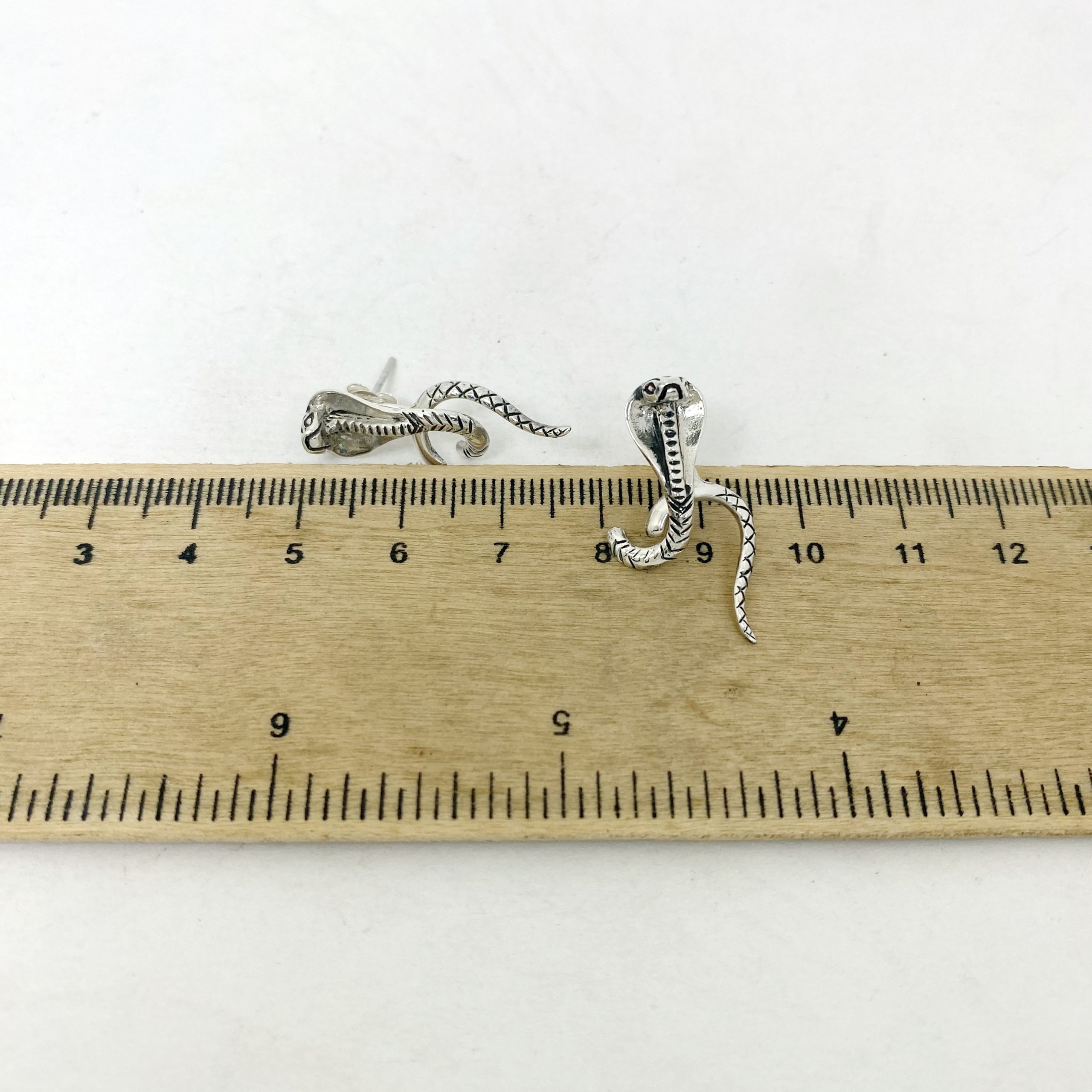 King Cobra Earring Jackets placed next to a wooden ruler to display dimensions.