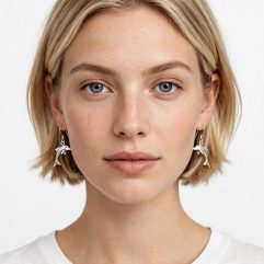 Front-facing portrait of a model wearing 925 sterling silver dolphin dangle earrings.