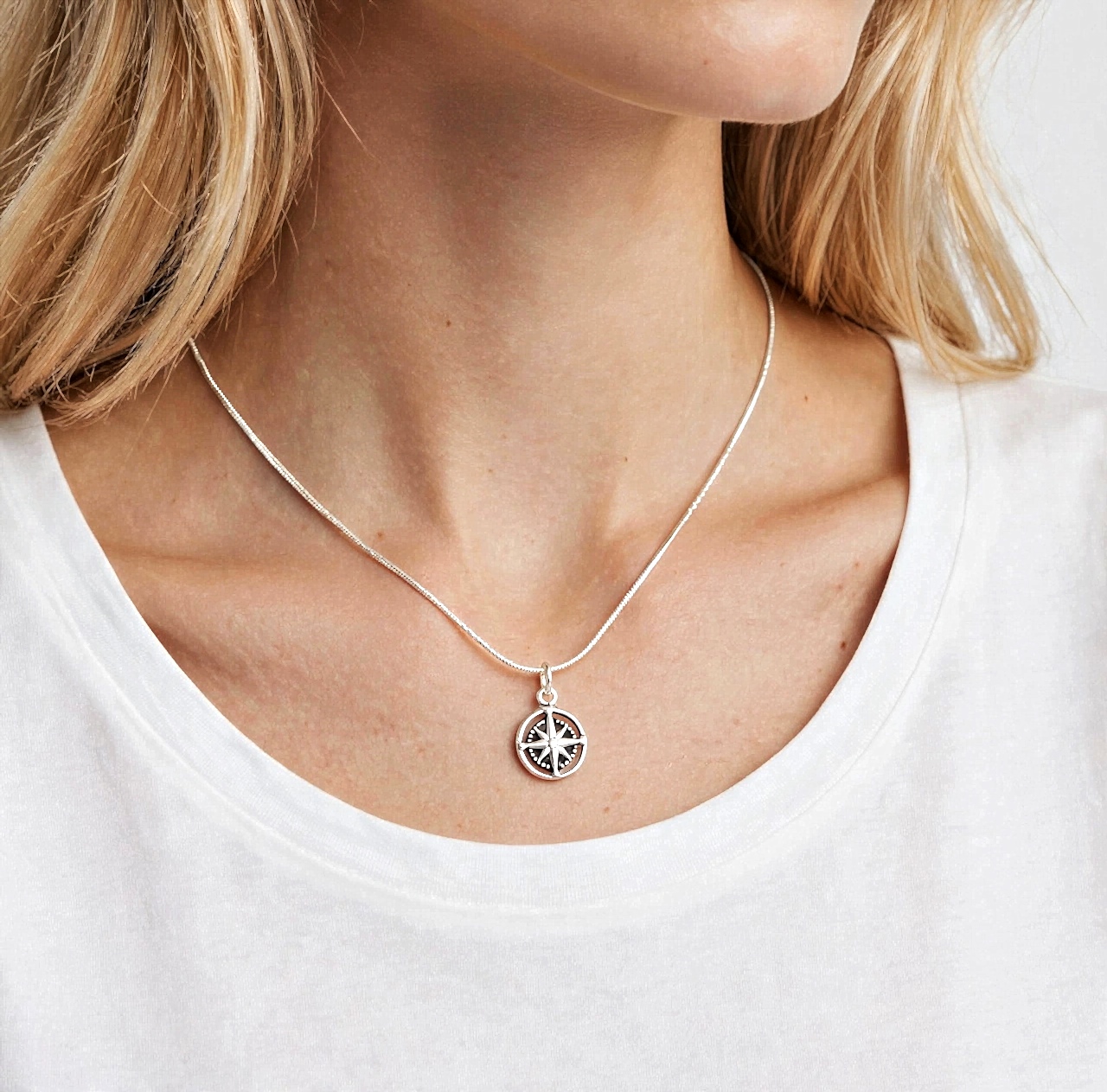 Model wearing the Sup Silver 925 sterling silver compass rose pendant on a thin silver chain over a white t-shirt.